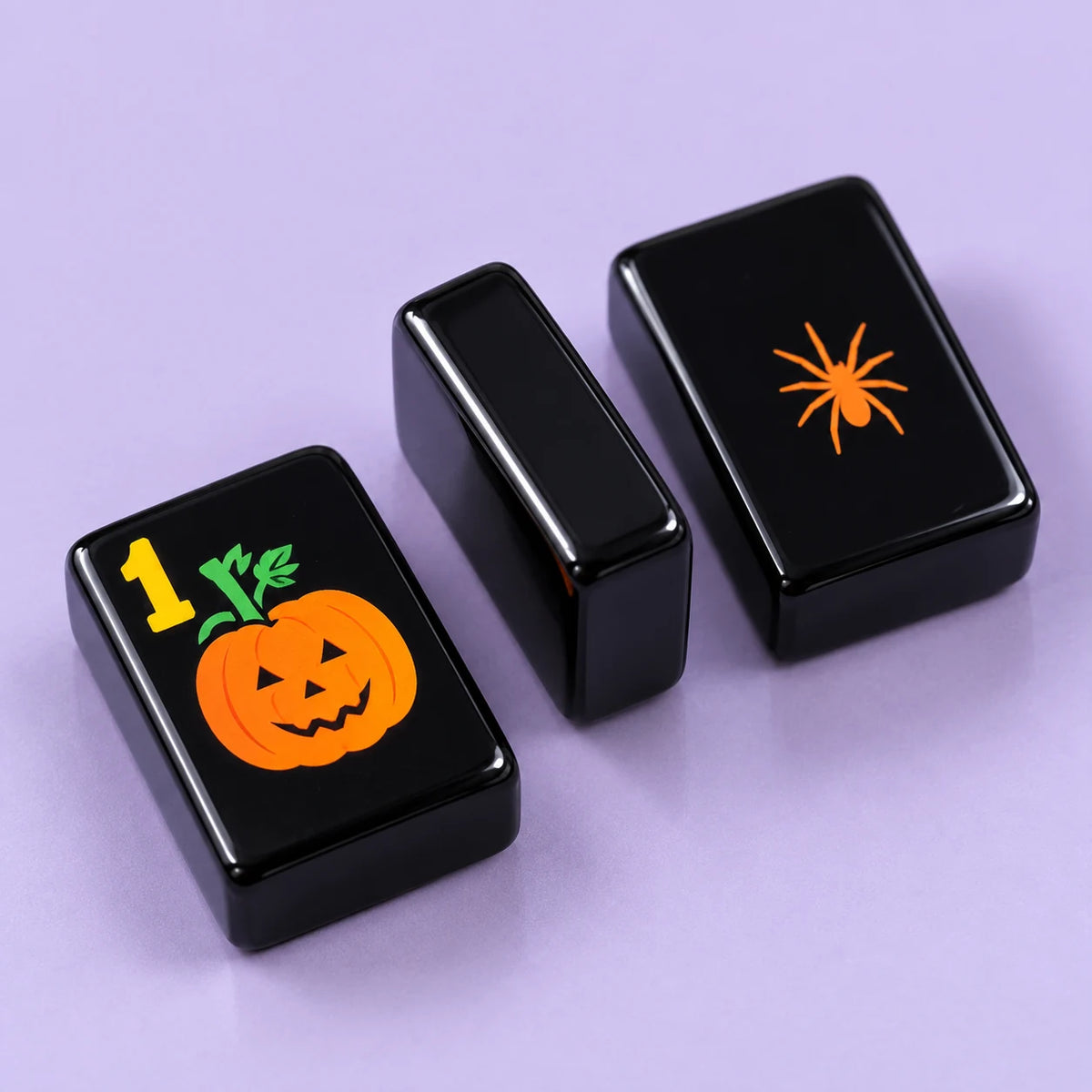 Midnight Mischief American mahjong tile, close view of the finish and black reverse with an orange spider